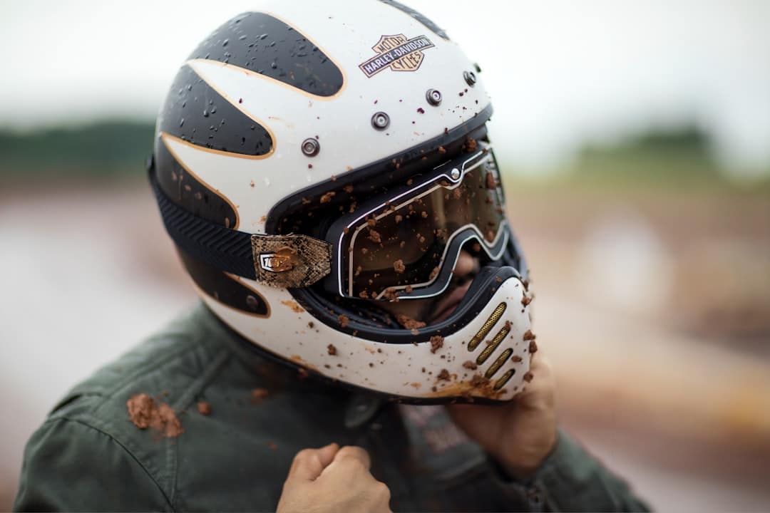 man wearing full face motorcycle helmet while covered in mud